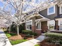 Charming home featuring neutral siding, brick accents, a covered entryway, and lush landscaping at 6301 Park South Dr, Charlotte, NC 28210