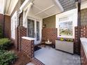 Inviting front porch with brick columns, a seating area, and seasonal decor at 6301 Park South Dr, Charlotte, NC 28210