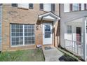 Close-up of townhome entrance with glass door and trimmed shrubbery at 6310 Windsor Gate Ln # 15, Charlotte, NC 28215