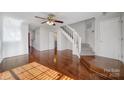 Open-concept living room with hardwood floors, ceiling fan, and staircase to upper level at 6310 Windsor Gate Ln # 15, Charlotte, NC 28215