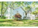 Charming blue brick home featuring a wooden siding, a porch, green lawn, and surrounded by mature trees at 6628 Cool Water Ct, Charlotte, NC 28215