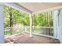 Inviting front porch with wood floors and open views of the surrounding trees at 6628 Cool Water Ct, Charlotte, NC 28215