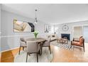 The combined living and dining area features a fireplace, hardwood floors, and a round table for four at 7707 Petrea Ln, Charlotte, NC 28227