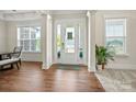 Bright foyer featuring hardwood floors, elegant trim, and a view of the staircase at 8601 Balcony Bridge Rd, Huntersville, NC 28078