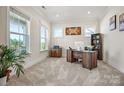 Cozy home office with ample natural light, a built-in bookcase, and neutral carpet at 8601 Balcony Bridge Rd, Huntersville, NC 28078