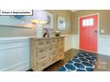 Inviting foyer with hardwood floors, a stylish console table, and a vibrant front door at 1049 Merganser Way, Indian Trail, NC 28079
