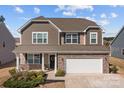 Beautiful two-story home featuring stone veneer, complementary siding, well-maintained landscaping, and a two-car garage at 141 Slip Shot Ln, Troutman, NC 28166