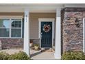 Close up of the home's front porch featuring stone accents, house number, and a decorative wreath on the front door at 141 Slip Shot Ln, Troutman, NC 28166