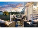 Cozy outdoor patio with comfortable wicker furniture, perfect for enjoying the backyard view on summer evenings at 14235 Canemeadow Dr, Charlotte, NC 28278