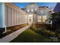 Inviting home exterior features a walkway leading to the front door, complemented by manicured landscaping and soft outdoor lighting at 14235 Canemeadow Dr, Charlotte, NC 28278