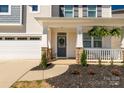 Inviting front porch with stone accents, a wreath on the door, and lush ferns at 1519 Arcadia Bluff Dr, York, SC 29745