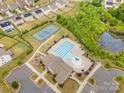Aerial view of community amenities including a swimming pool, tennis court, playground and clubhouse at 16200 Winfield Hall Dr, Charlotte, NC 28273