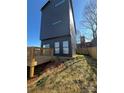 Backyard with a small wooden deck, minimal grass, and a tall gray home exterior at 211 S Webb St, Gastonia, NC 28052