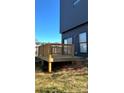 A backyard with a wooden deck and minimal landscaping, beneath a clear blue sky at 211 S Webb St, Gastonia, NC 28052