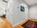 Hallway with hardwood floors and neutral gray walls, offering a glimpse into the rest of the home at 2310 Roswell Ave # H, Charlotte, NC 28207