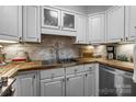 Bright kitchen featuring white cabinets, stainless steel sink, and wooden countertops at 2503 Roswell Ave # 208, Charlotte, NC 28209