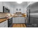 Charming kitchen featuring white cabinets, stainless steel appliances, and wooden countertops at 2503 Roswell Ave # 208, Charlotte, NC 28209