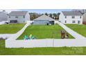 Expansive fenced-in backyard featuring lush green lawn, fire pit, playset, and outdoor seating; ideal for Gathering enjoyment at 2766 Sherrills Stream Dr, Sherrills Ford, NC 28673