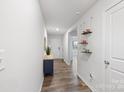 Bright and inviting hallway with hardwood flooring, and decorative shelving, adjacent to the front door at 2766 Sherrills Stream Dr, Sherrills Ford, NC 28673