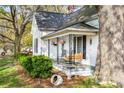 Inviting front porch with hanging flower baskets, a swing, and seating for relaxing outdoors at 310 N Central Ave, Landis, NC 28088
