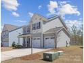 Charming two-story home featuring a two-car garage and beautifully landscaped front yard, with light-grey siding at 314 Contentment Dr # 192B, Locust, NC 28097