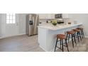 Modern kitchen featuring stainless steel appliances, a breakfast bar, and light wood grain floors at 336 B Lincoln St, Concord, NC 28025