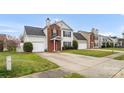 Charming two-story home featuring a red front door, brick accents, green lawn, and attached garage at 4917 Spruce Peak Rd, Charlotte, NC 28278