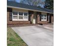 Brick townhouse showcasing a cozy front yard and individual driveways for each unit at 504 Camrose Ne Cir, Concord, NC 28025