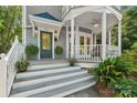 Inviting front porch and stairs featuring decorative plants, sconce lighting, and a painted teal front door at 545 Dilworth Mews Ct, Charlotte, NC 28203