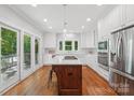 Bright, updated kitchen with stainless appliances, a center island with gas cooktop, and white cabinetry at 545 Dilworth Mews Ct, Charlotte, NC 28203