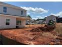 Image of backyard with unfinished landscaping. Construction vehicles on site at 5626 Skinny Dr, Charlotte, NC 28215