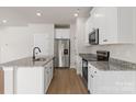 Modern kitchen with stainless steel appliances, granite countertops, and a functional island at 5626 Skinny Dr, Charlotte, NC 28215
