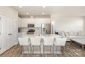 Bright, modern kitchen with stainless steel appliances, an island with bar seating, and seamless connection to the living area at 6048 Chelsea Oaks Rdg, Tega Cay, SC 29708