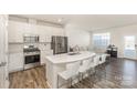 Bright, modern kitchen with stainless steel appliances, an island with bar seating, and seamless connection to the living area at 6048 Chelsea Oaks Rdg, Tega Cay, SC 29708