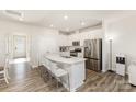 Bright, modern kitchen with stainless steel appliances, an island with bar seating, and seamless connection to the living area at 6048 Chelsea Oaks Rdg, Tega Cay, SC 29708