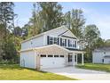 Charming two-story home with a light blue finish, complemented by lush landscaping and a driveway at 6217 Rockwell W Blvd, Charlotte, NC 28269