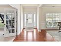 Elegant foyer with hardwood floors, decorative door with sidelights, and wainscoting at 9895 Travertine Trl, Davidson, NC 28036