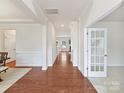 Bright hallway featuring hardwood floors, crown molding, and access to various rooms at 9895 Travertine Trl, Davidson, NC 28036