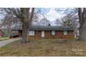 Charming single-story brick home with blue shutters and mature trees in a residential neighborhood at 103 Perry St, Shelby, NC 28150