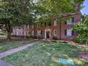 Charming brick apartment building featuring mature trees and manicured lawn at 107 S Laurel Ave # 101A, Charlotte, NC 28207
