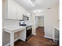 Modern kitchen boasts stainless steel appliances, white cabinets and bar-top counter at 107 S Laurel Ave # 101A, Charlotte, NC 28207