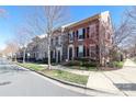 Attractive townhome exteriors showcasing brickwork, black shutters, and manicured landscaping at 10810 Kemptown N Sq, Charlotte, NC 28227