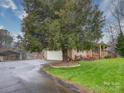 Ranch home featuring an attached garage and mature landscaping at 1115 Kelly Rd, Mount Holly, NC 28120