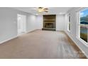 Spacious living room with fireplace, ceiling fan, neutral carpet, and a large window at 1125 Twin Lakes Rd, Rock Hill, SC 29732