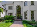 Elegant front entrance featuring a brick walkway, arched doorway and beautiful landscaping at 12014 James Jack Ln, Charlotte, NC 28277