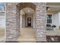 Stone entryway leading to the front door, with a bench, and landscaping around the porch at 129 Doncaster Dr, Mooresville, NC 28115