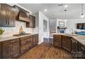 Modern kitchen with dark wood cabinets, granite countertops, stainless steel appliances, and hardwood flooring at 13240 Carolina Wren Ct, Charlotte, NC 28278