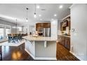 A kitchen with granite countertops, an island, stainless steel appliances, and hardwood floors at 13240 Carolina Wren Ct, Charlotte, NC 28278