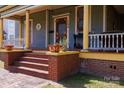 Inviting porch with brick steps, colorful columns, and decorative planters, offering a charming entryway to the home at 143 Reid St, Rock Hill, SC 29730