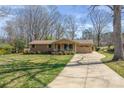Inviting home exterior with a long driveway, mature trees, and a lush green lawn at 1630 26Th Ne St, Hickory, NC 28601